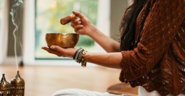 woman in brown knit sweater holding brown ceramic cup